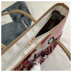 Detail view of the secure gold metal zipper closure on the patterned canvas tote bag