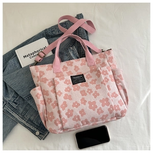 Detail of pink floral canvas tote with Fashion Instinct label and bronze hardware