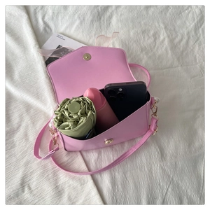 Detail view of pink crossbody bag interior showing space for phone and umbrella
