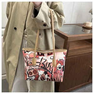 Detail of graffiti print tote bag with street art patterns and leather double handles