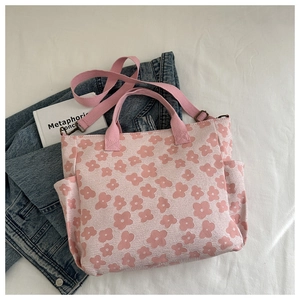 Flat lay of pink floral canvas bag with side pocket, styled with jeans and a book