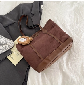 Vue détaillée du sac cabas marron contrasté en suédine avec un charm d'ours en peluche