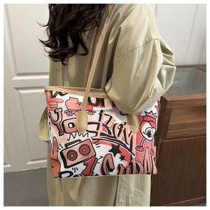 Side view of large tote bag with colorful graffiti prints on model's shoulder
