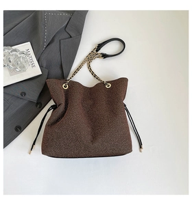 Dettaglio della borsa tote marrone glitterata con coulisse e tracolla a catena dorata