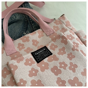 Detail of floral pattern on tote bag with Fashion Instinct label and pink handle
