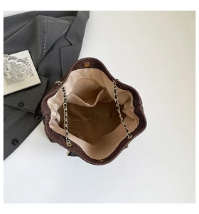 Dettaglio interno di una borsa tote con paillettes marroni, fodera in raso e tasche