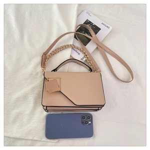 Detail view of pink flap crossbody bag with gold square metal buckle and chain strap