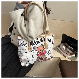 Detail of white tote bag featuring artistic graffiti illustrations and fluffy cloud charm