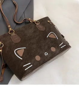 Detail of cute cat print on large brown tote bag with high-quality golden hardware
