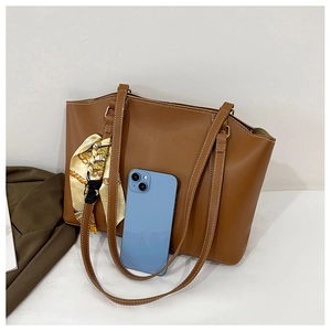 Comparaison de taille du sac cabas en cuir marron avec un smartphone spacieux