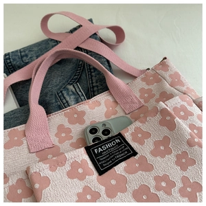 Detail of floral canvas tote bag with front pocket showing smartphone storage capacity