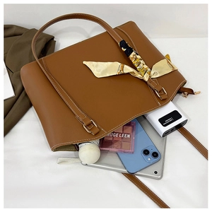 Grand sac cabas marron montrant sa capacité avec téléphone, parapluie et maquillage