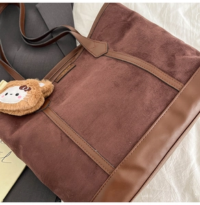 Détail du sac cabas en daim marron avec garniture en cuir et breloque ours en peluche