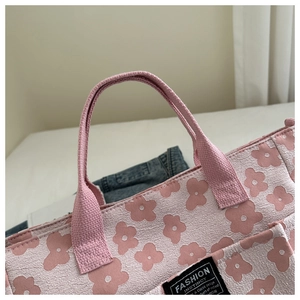 Detail of pink canvas tote bag with floral patterns and sturdy fabric handles