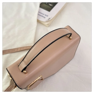 Top view of beige faux leather handbag with gold hardware and sleek edge finish