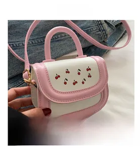 Detail of mini pink and white leather crossbody bag with cute red cherry prints