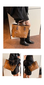 Detail einer braunen Wildleder-Tragetasche mit minimalistischem Katzendesign und Henkeln