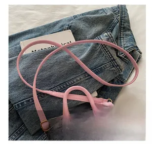 Detail view of pink crossbody bag with cherry print and adjustable shoulder strap