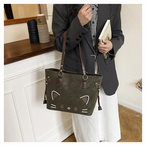 Detail of dark green tote bag with cute cat face design and brown double handles