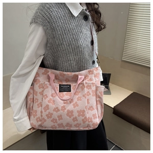 Detail view of pink floral canvas tote bag featuring multiple pockets and durable straps