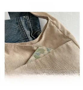 Détail du sac cabas en velours côtelé beige avec poche latérale et texture à côtes