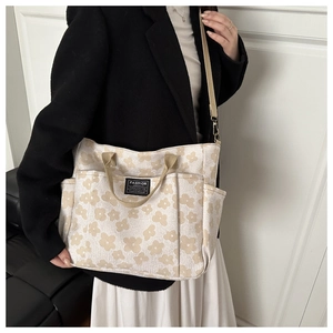 Close-up of floral print tote bag with adjustable strap and fashion label detail