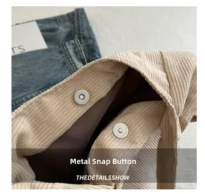Détail d'un sac en velours côtelé beige avec bouton magnétique argenté et doublure