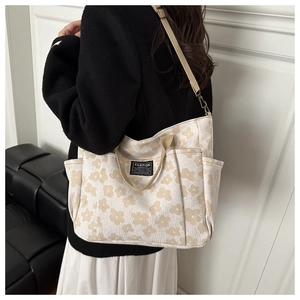 Detail of floral canvas tote bag showing side pocket and Fashion Instinct woven label