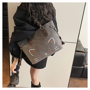 Close-up of cute cat pattern on gray faux leather shoulder bag with dark straps
