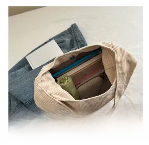 Vue intérieure montrant la grande capacité du sac fourre-tout en velours côtelé beige à aimant