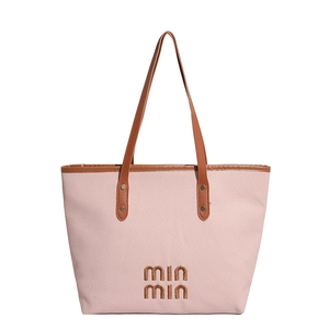 Pink canvas tote bag with brown leather handles and min min embroidery on white background