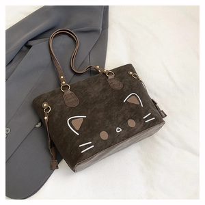 Detail einer dunkelbraunen Wildleder-Tragetasche mit minimalistischem Katzen-Design