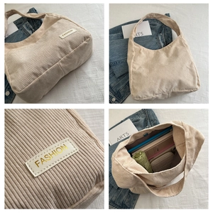 Détail du sac cabas en velours côtelé blanc cassé montrant l'intérieur et le patch logo