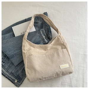 Détail du sac hobo en velours côtelé beige avec poche avant et large bandoulière