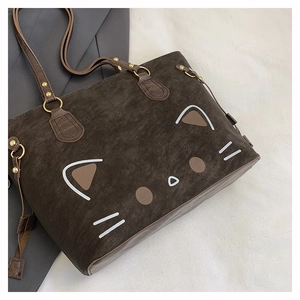 Detailansicht der dunkelbraunen Totebag mit Katzenmuster und goldenen Metallbeschlägen