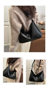 Close-up of black leather hobo bag with adjustable shoulder strap and pleated texture