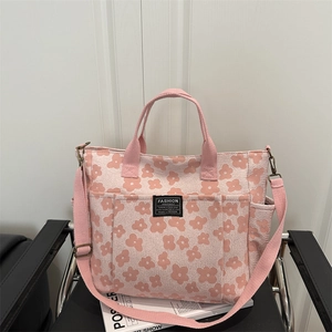 Pink floral canvas tote bag with multi-pocket design and adjustable shoulder strap