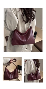Detailed view of dark red leather shoulder bag showing texture and crescent shape