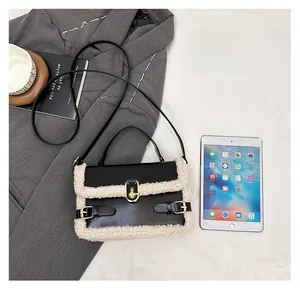 Detail view of small black crossbody bag with faux shearling trim and gold twist lock