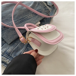 Detailed close-up of pink and white patchwork mini bag with cute cherry pattern print