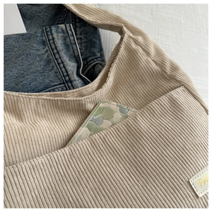 Détail du sac cabas en velours côtelé beige avec poche avant et logo FASHION