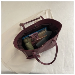 Interior view of large burgundy tote bag showing magnetic closure and spacious capacity