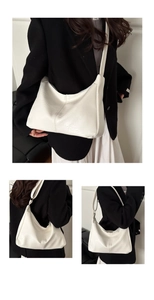 Close-up of minimalist cream white crescent hobo bag with soft leather texture
