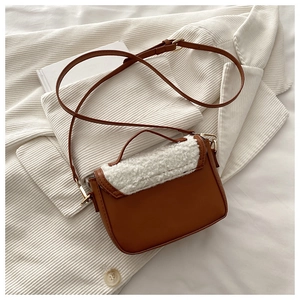 Close-up of the vintage saddle bag showing brown leather and white plush texture details