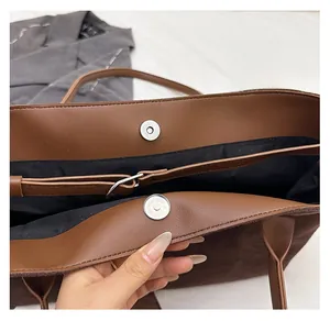 Close-up of magnetic snap closure and suede texture on brown tote shoulder bag
