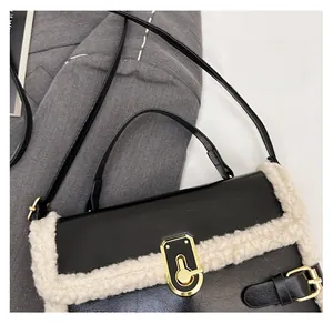 Close-up of black leather bag with white plush wool trim and golden metal rotary lock