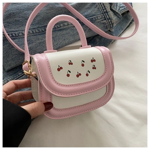 Detail of pink and white mini bag with cherry print and versatile detachable strap