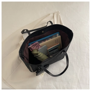 Detail view of large tote bag interior showing spacious capacity with tablet and umbrella