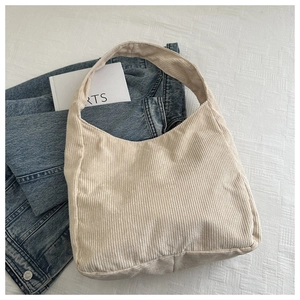 Gros plan de la texture du sac hobo en velours côtelé beige sur un jean