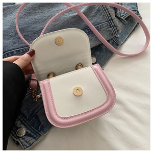 Close-up of pink and cream saddle bag showing magnetic snap closure and interior